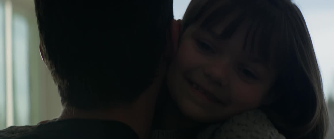 A child running up and hugging a man and talking to him