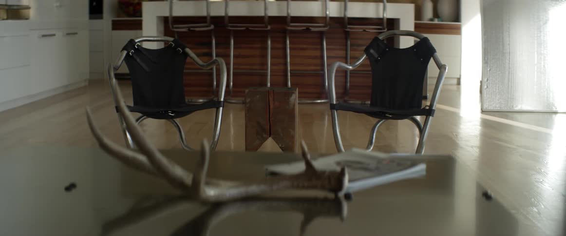 The large room is empty with two chairs