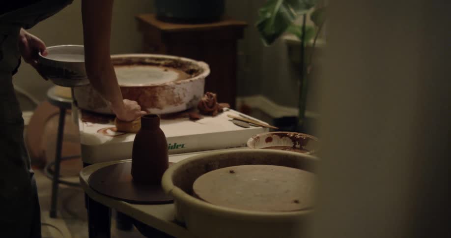 A person cleaning up their mess after making some pottery