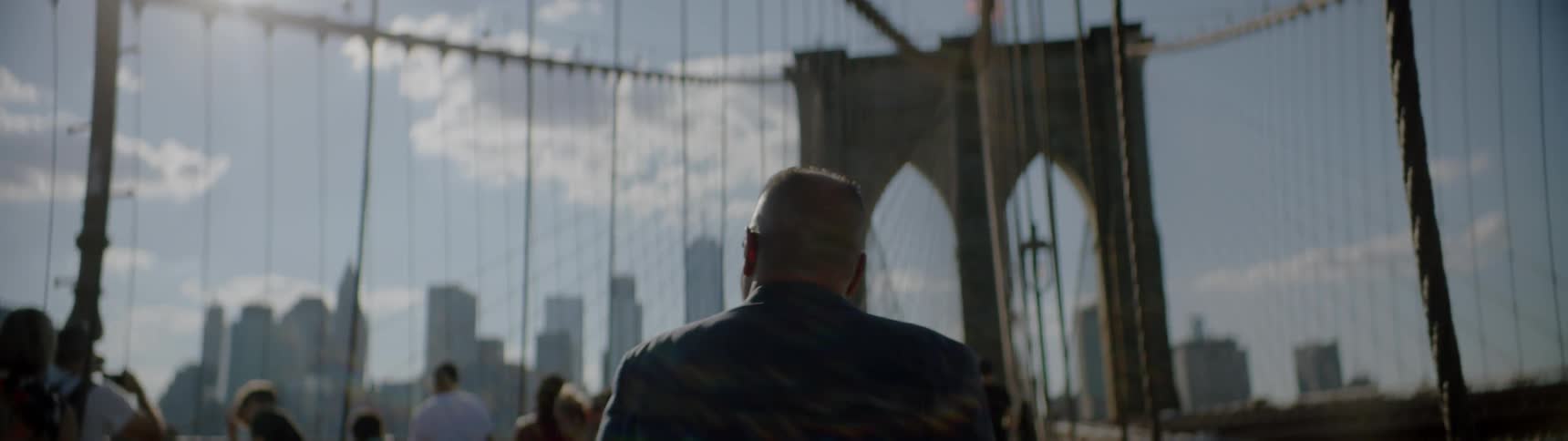 Man walks across a city bridge