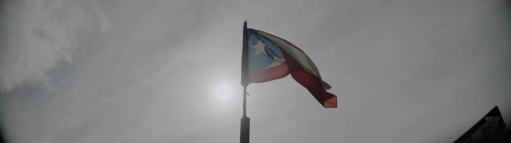 The flag of puerto rico blows in the wind on a sunny day