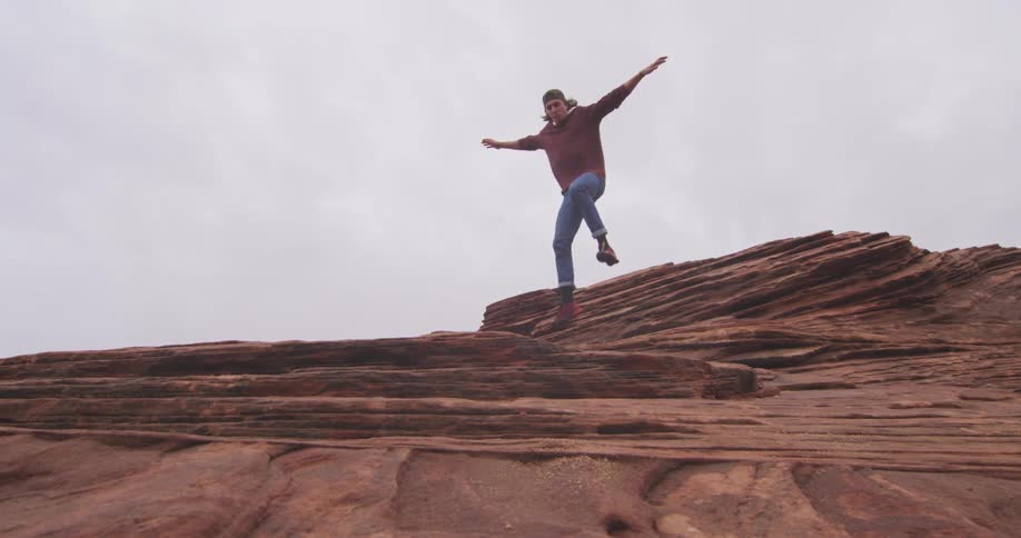 A climbing down some large rocks