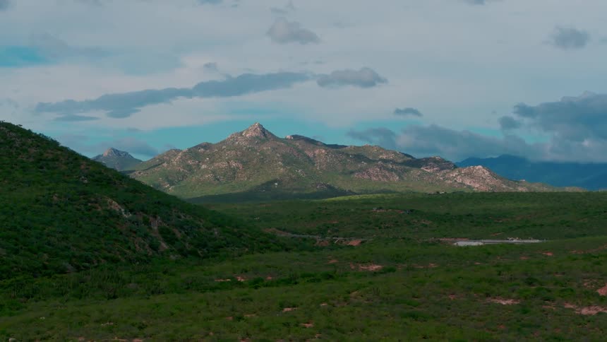 Rolling green hills near mountains