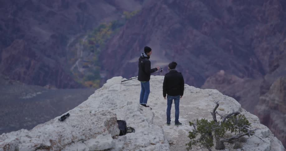 Men stand on a large boulder in the wilderness