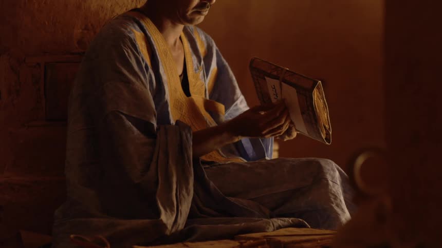 A man wraps a book with a cord
