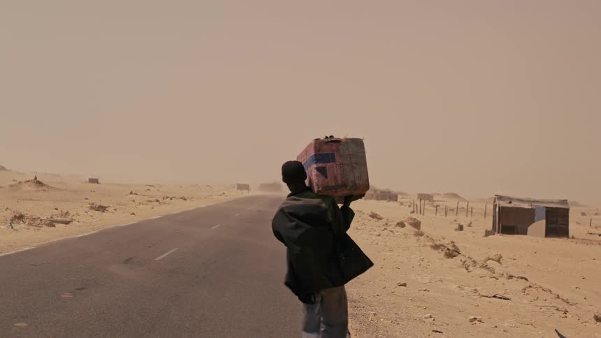 A man is carrying a package down the road