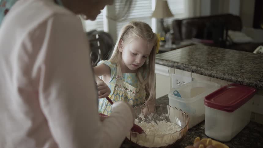 A child mixes the flour in the bowl