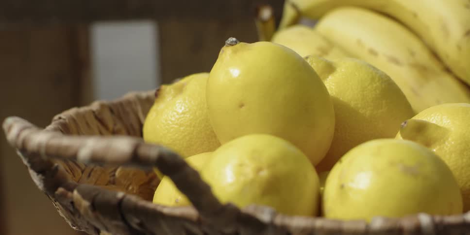 Lemons and bananas sit in a basket