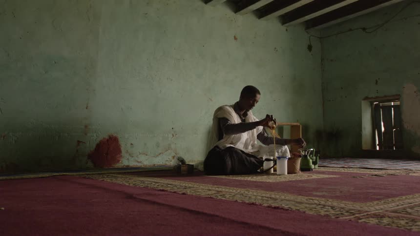 A man pours tea into a plastic cup