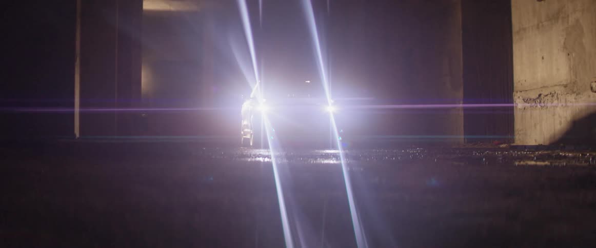 Headlights of a vehicle turning off and on in a dark area