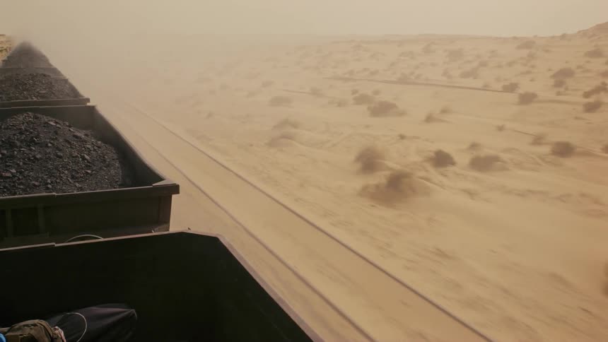 The train is moving trailers across the desert