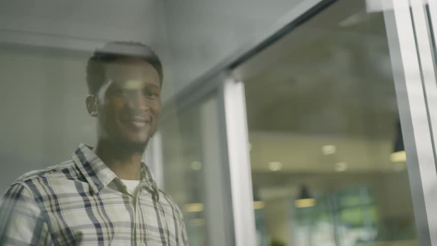 A man is using a marker to draw on a glass window