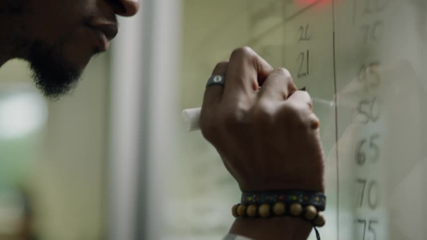 Man writes on a window with a marker