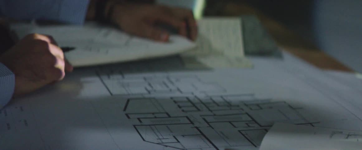 A man makes marks on a schematic drawing