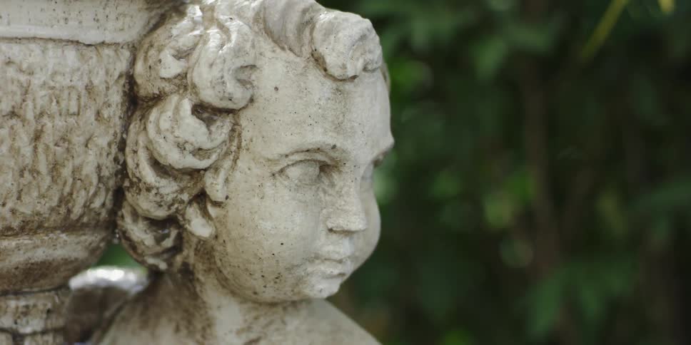 Water pours over a cherub statue