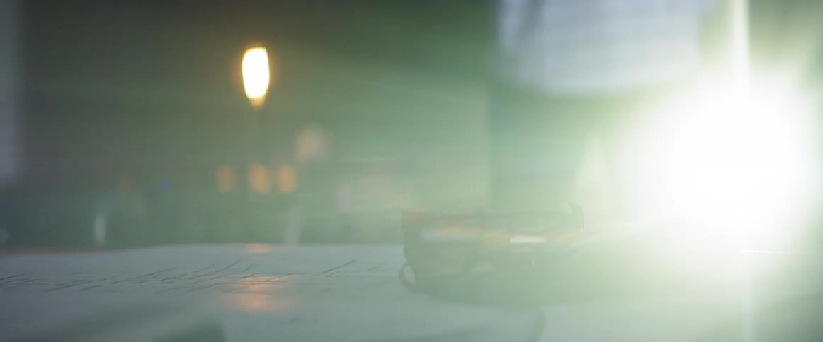 A person stands near a table with blueprints on it