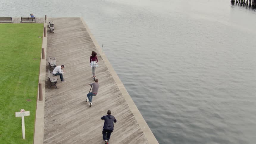 People ride scooters on the docks