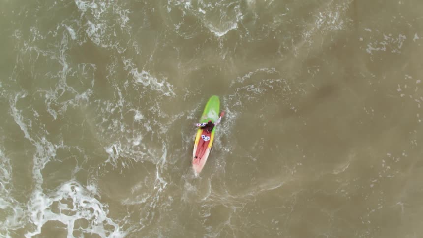 A woman paddles out on her surfboard