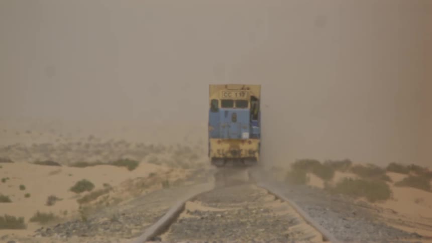 A freight train travels on desert tracks