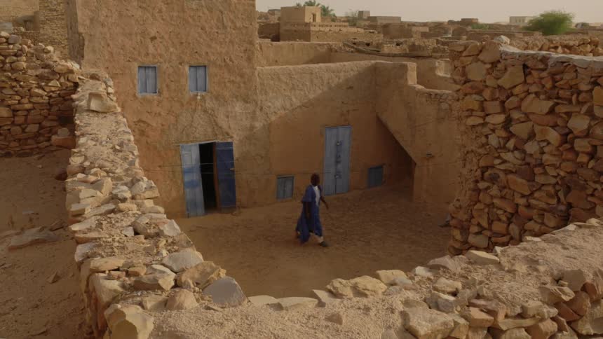 Man exits a desert stucco building