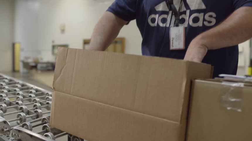 A man checks a package before sealing it