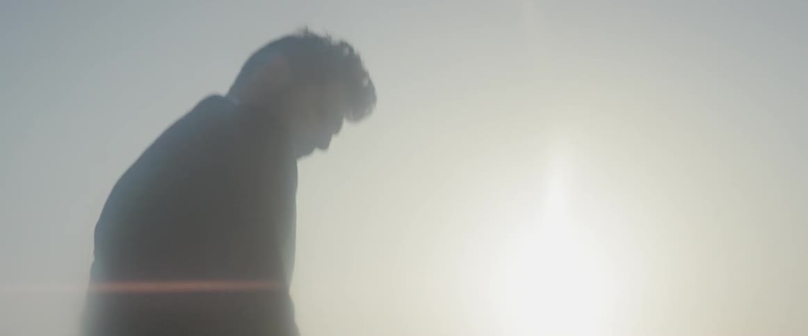 A man stands outside in the sun