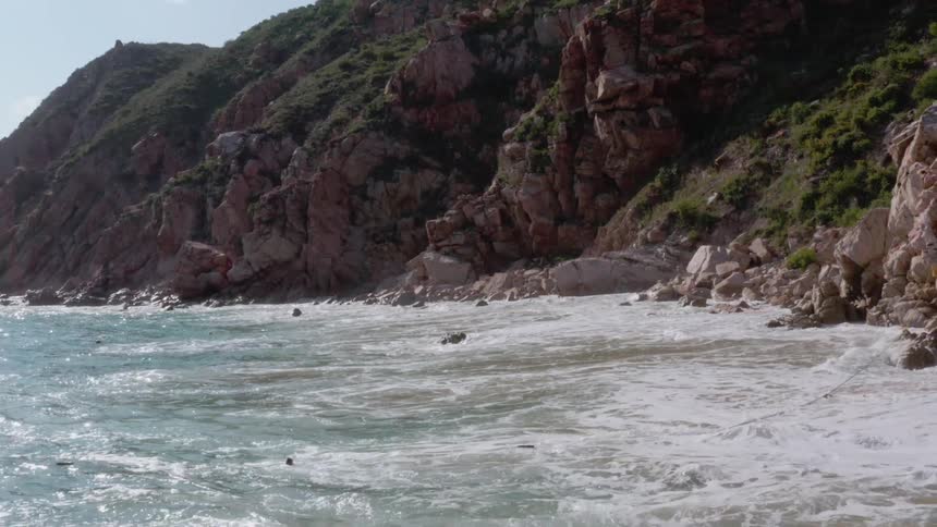 Ocean waves splash against the rocks on shore
