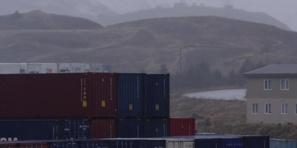 Shipping containers stacked beside a road