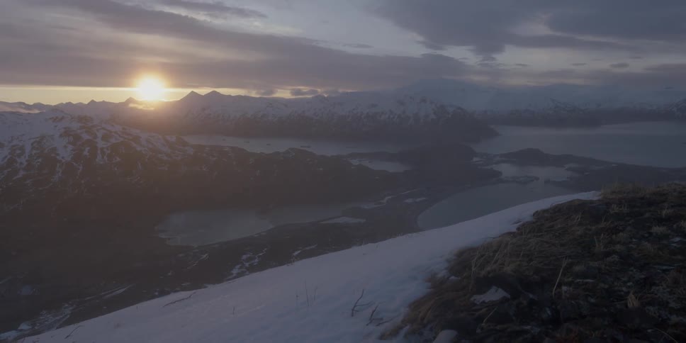 The sun sets over snow capped mountains