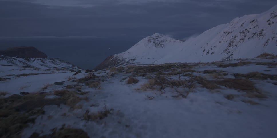 Snow covers mountains on a cloudy day