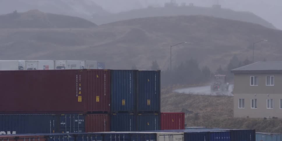 Snow falls on stacked shipping containers