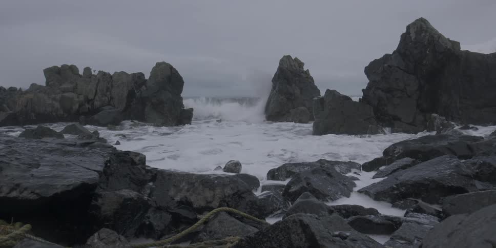 Ocean waves crash into a rocky shore
