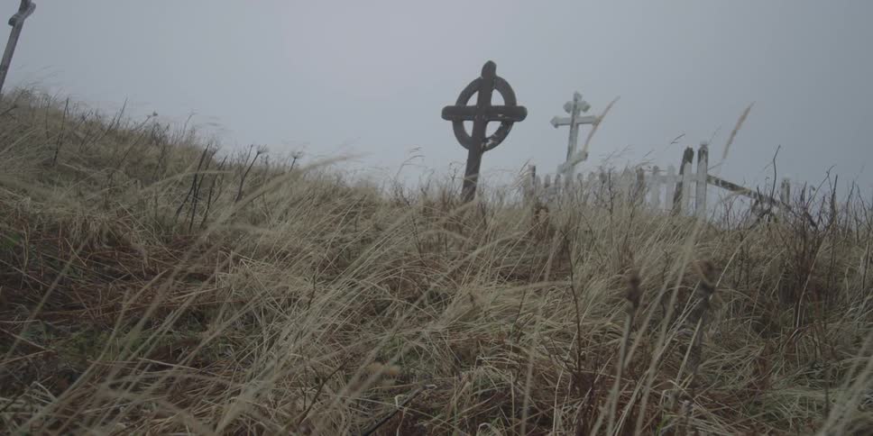 Crosses sit on a grassy hill
