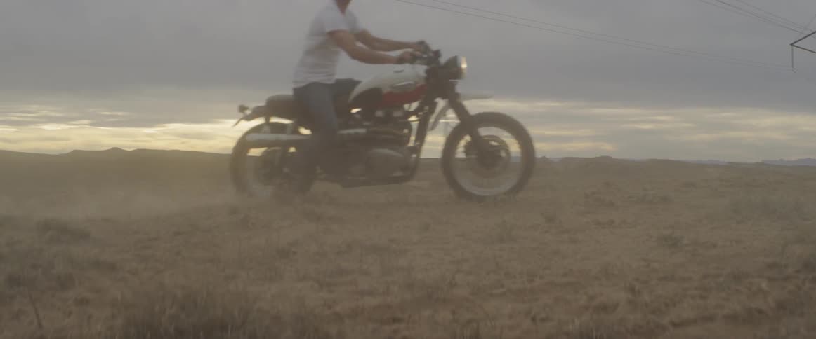 A person drives across a dusty area