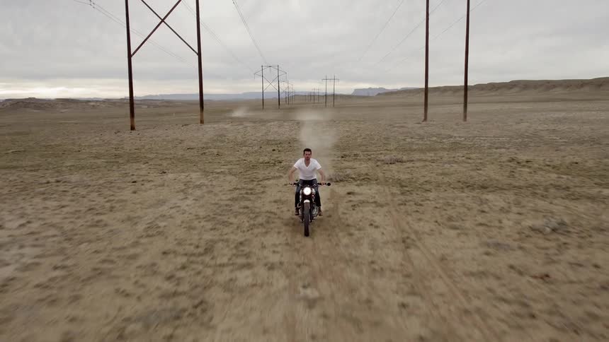 A mans stands up while racing his motorcycle