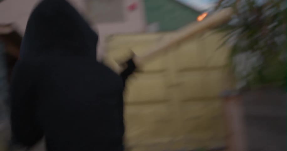 A person attempts to break a car window with a stick