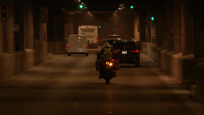 Traffic is flowing through a tunnel at night