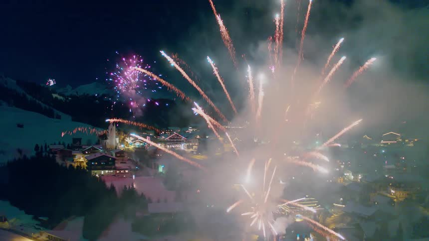 Fireworks explode over a snowy village