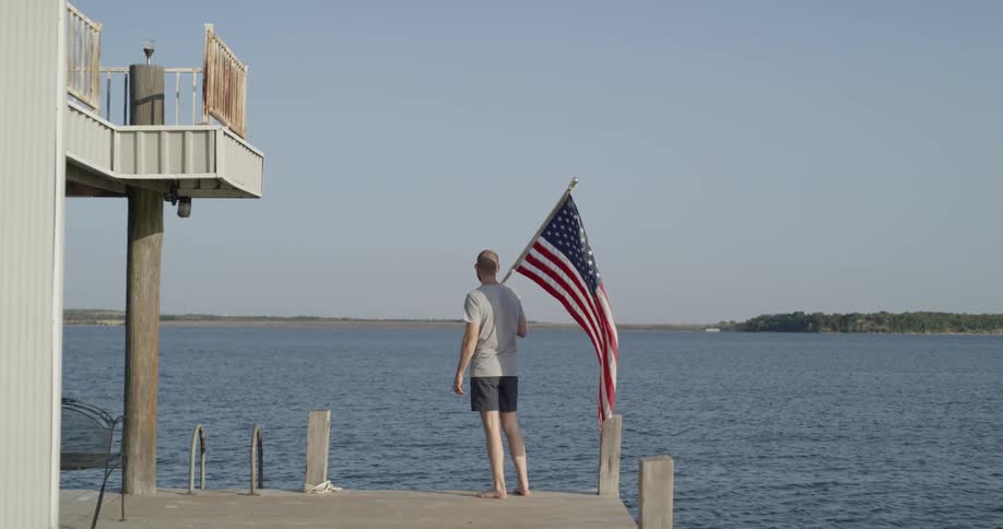 A man holding a flag on a pier