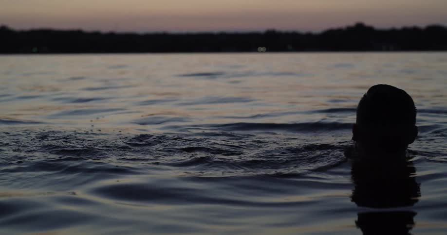 Someone is swimming in a lake