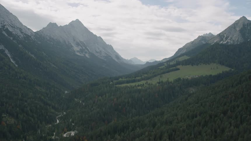 Trees and a stream lie between mountains