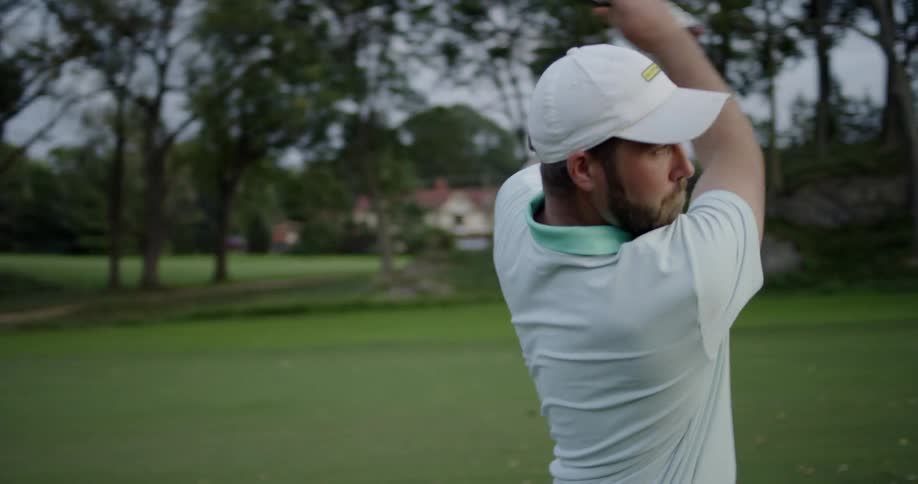 A man takes a swing on a golf course