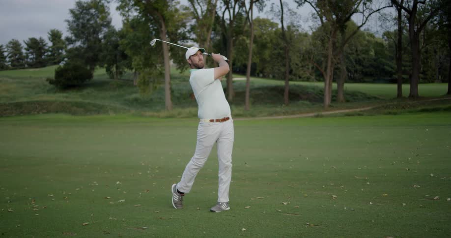 A golfer hits a ball on the green