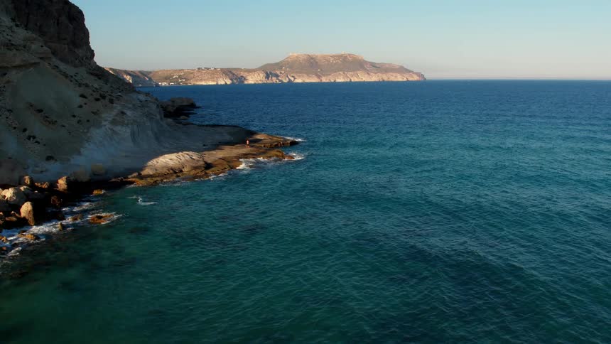 Aquamarine waves of the Mediterranean swoop over the rocky shore