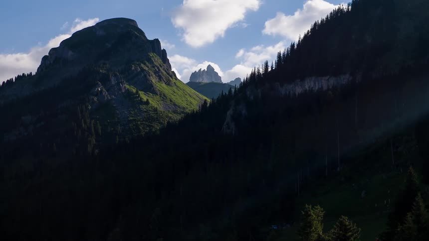 Clouds over tree covered mountains