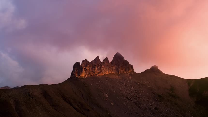 The dawn sky is full of large clouds over the mountain