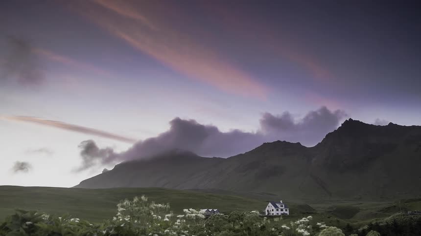 Dark clouds pass above the mountain