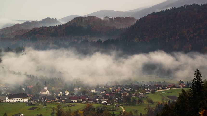 Fog and haze lift above a mountain valley near Bled lake in Slovenia