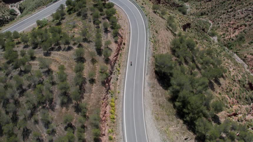 A bicyclist rides down a mountain road in Southern Spain