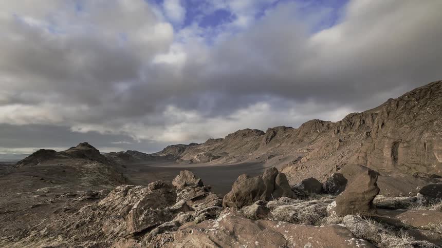 Clouds move over rocky hills